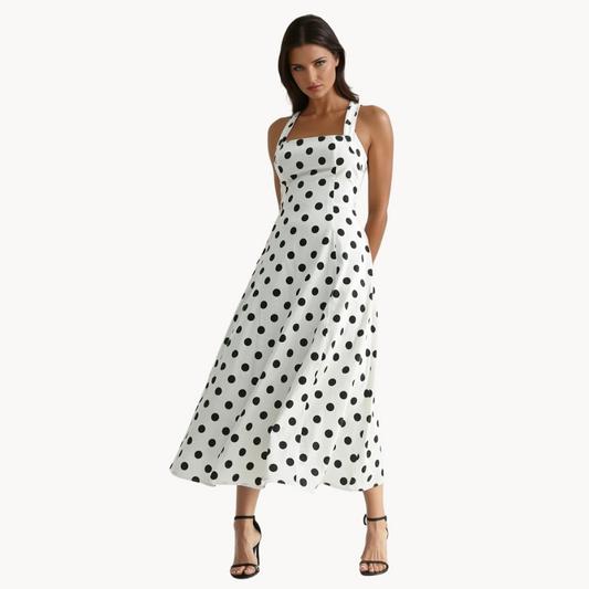 White midi dress with black polka dots, wide straps, and flared silhouette – vintage-inspired brunch dress or classy summer outfit for women.