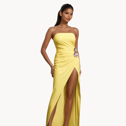 Yellow strapless gown with side slit, floral applique detail, and ruched fit – statement evening dress or summer wedding guest outfit for women.