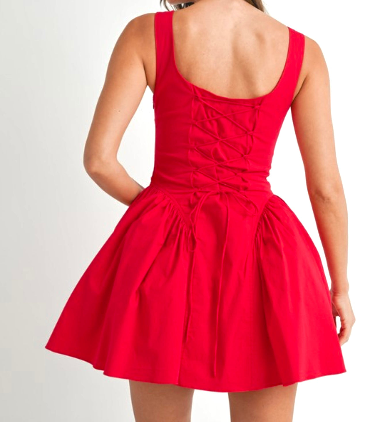 Red corset-style mini dress with pleated skirt and lace-up back – flirty and bold date night outfit or party dress for women.
