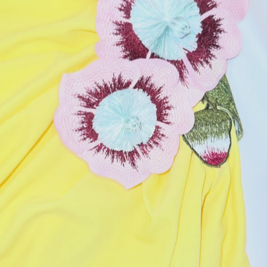 Yellow strapless gown with side slit, floral applique detail, and ruched fit – statement evening dress or summer wedding guest outfit for women.